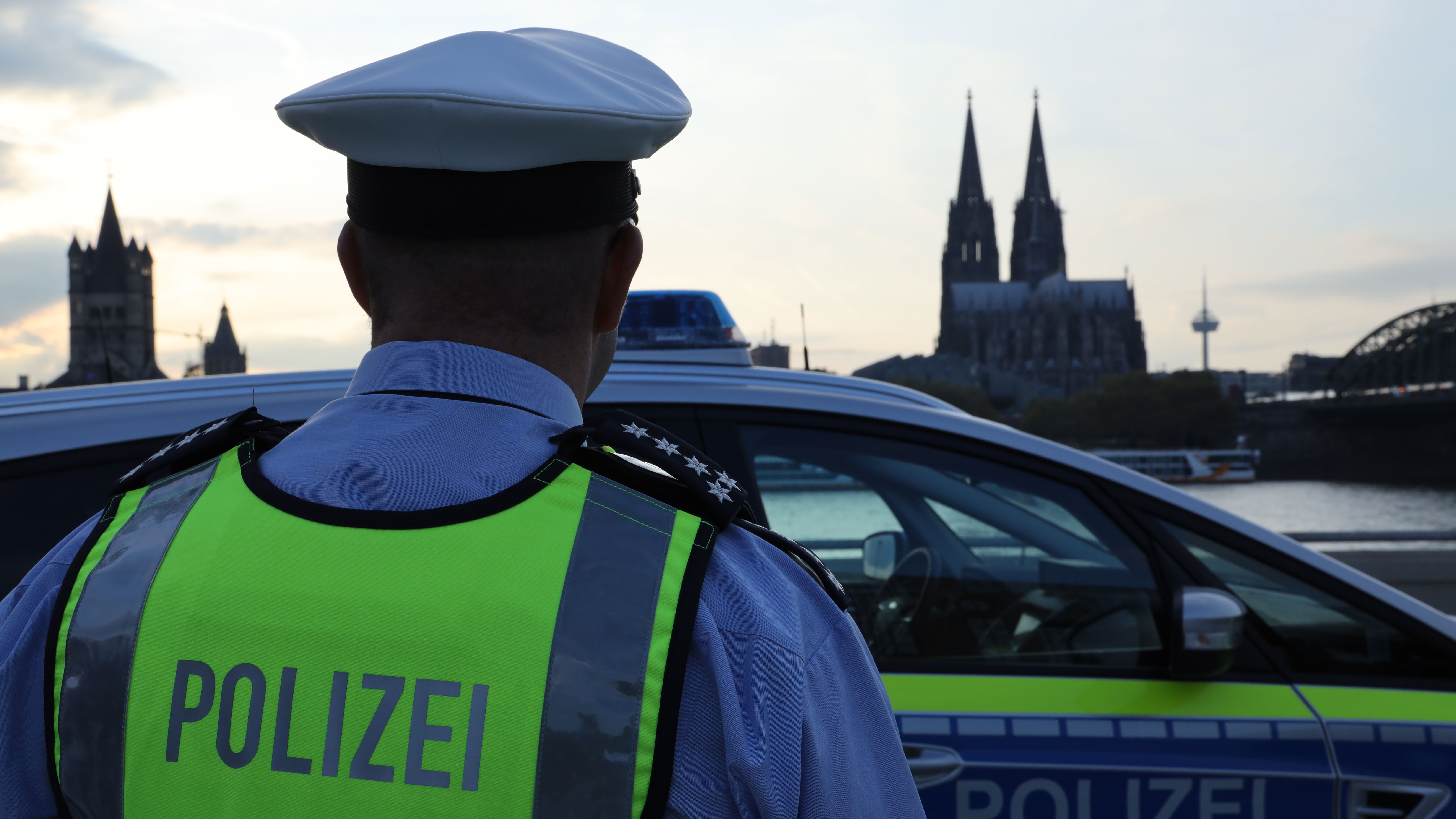 Police officer in front of patrol car in Cologne