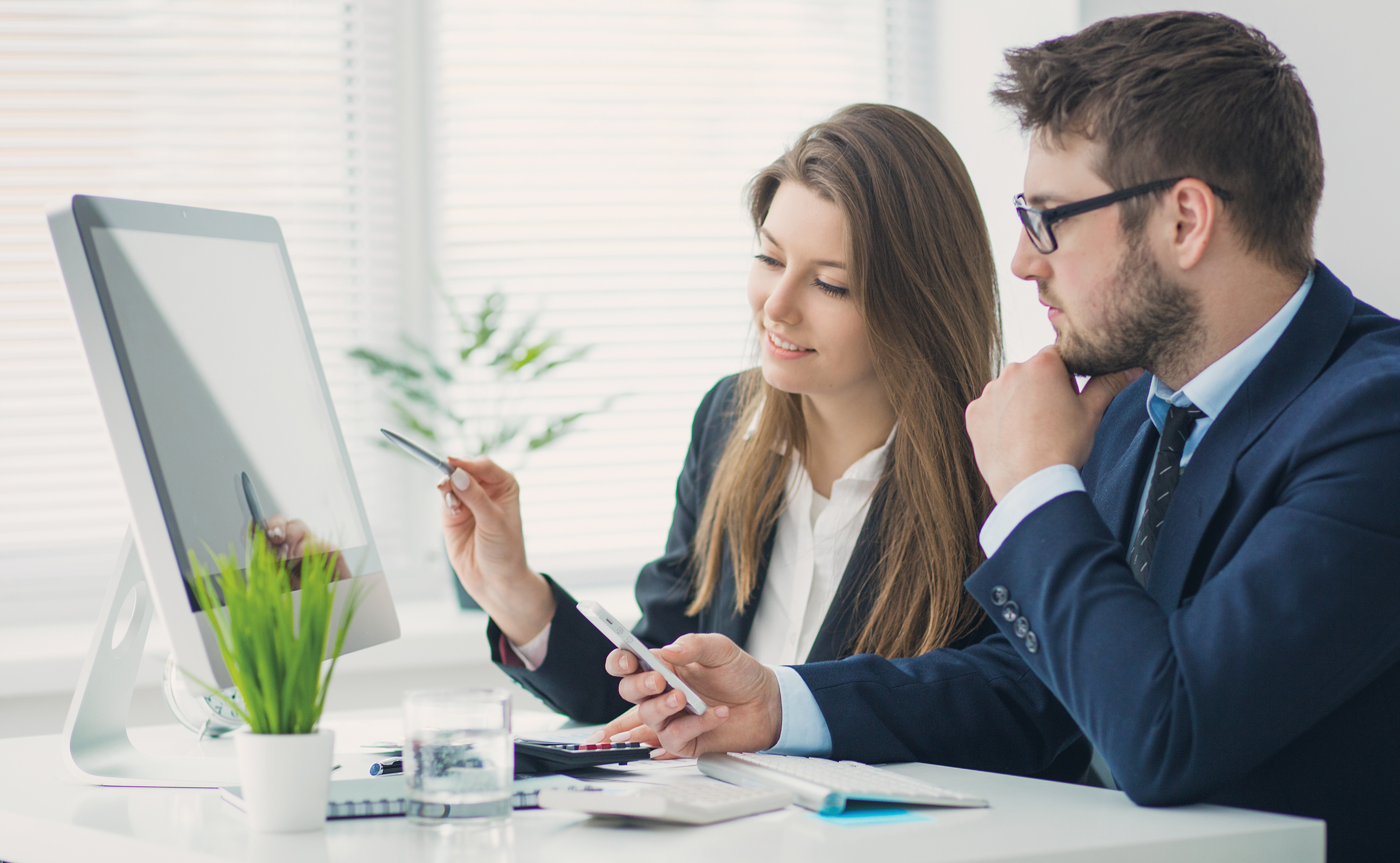 Büro Mann und Frau vor Bildschirm